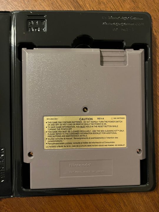 The back of a NES cartridge in a black clamshell